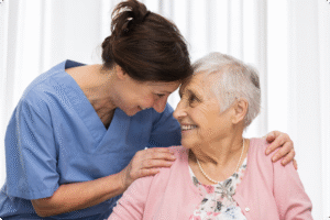 Healthcare worker and elderly woman share a joyful moment, emphasizing compassionate care in a bright, welcoming environment.