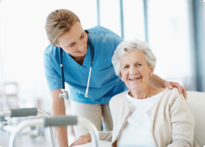A smiling senior woman is accompanied by a compassionate caregiver in a bright, healthcare setting.