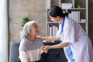 A healthcare professional interacts warmly with an older woman in a modern waiting area, showcasing compassionate care.