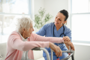 A healthcare professional assists an elderly woman with a walker in a bright, welcoming indoor environment.